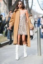 Model wears a sequined dress, a brown overcoat and a pair of white boots during the Armani fashion show at the women`s fashion wee