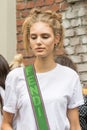 Model wears a white cotton shirt and a shoulder strap of a green Fendi handbag