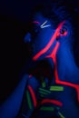 Model woman in neon light, beautiful model girl with fluorescent makeup, art design of disco dancer dancing in uv light Royalty Free Stock Photo