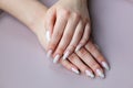 Model woman showing .light white nude shellac manicure on long n