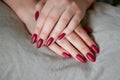 Model woman showing red shellac manicure on long nails