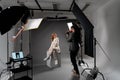 Model young woman preparing posing for photo taken with professional photographer in studio on fashion concept