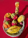 Modeling clay figure, giraffe, water apple, banana, slice of lemon and corn on red background