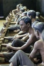 Models of detained prisoners by lock their foot ankle on something like wooden console at Hoa Lo Prison Museum in Hanoi, Vietnam