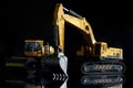 Models of excavator and asphalt roller on black background with reflection. Concept of equipment for construction, road and land Royalty Free Stock Photo