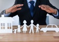 Models hands protecting house family and car cut outs Royalty Free Stock Photo