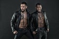 Models wearing leather jackets on bare torsos, fashion concept. Bikers with six pack and tattooed chests. African man