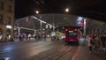 Moder architecture glass roof tram and bus stop in Bern city center, many people walking accross the street.