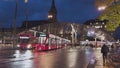 Moder architecture glass roof tram and bus stop in Bern city center, many people walking accross the street.