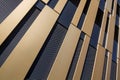 Modern, abstract house facade with gold-coloured and black elements from an oblique angle, as background to architecture