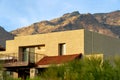 Modern adobe building in hidden desert neighborhood with white stucco exterior and flat roof style with front yard trees