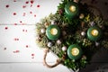 Modern Advent arrangement with lit candles on wooden table