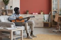 Modern African-American Man Playing Guitar at Home Royalty Free Stock Photo