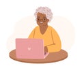 Modern afro american grandma with a laptop. Happy old senior woman sitting at desk with computer.