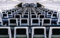 Modern aircraft interior with seats and blank touch entertainment Royalty Free Stock Photo