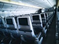 Modern aircraft interior with seats and blank touch entertainment Royalty Free Stock Photo