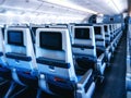 Modern aircraft interior with seats and blank touch entertainment Royalty Free Stock Photo