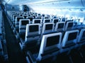 Modern aircraft interior with seats and blank touch entertainment Royalty Free Stock Photo