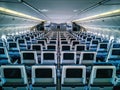 Modern aircraft interior with seats and blank touch entertainment Royalty Free Stock Photo