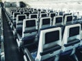 Modern aircraft interior with seats and blank touch entertainment Royalty Free Stock Photo