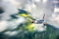 Modern airplane with motion blur effect is flying in clouds at sunset. Passenger airplane Royalty Free Stock Photo