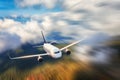 Modern airplane with motion blur effect is flying in low clouds at sunset. Passenger airplane Royalty Free Stock Photo