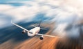 Modern airplane with motion blur effect is flying over low clouds Royalty Free Stock Photo