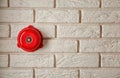 Modern alarm bell on brick wall indoors