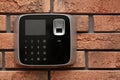 Modern alarm system with fingerprint scanner on brick wall. Royalty Free Stock Photo