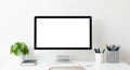 A modern all-in-one desktop computer with a blank white screen on a clean white desk with office supplies Royalty Free Stock Photo