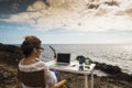 Modern and alternative lifestyle office wokstation with free business woman at work in open office with scenic ocean view -