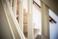 Modern american design white wooden stairs. Carpeted stairs and a wooden banister and railing are visible