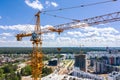 Yellow building cranes on construction site against blue sky background. Royalty Free Stock Photo