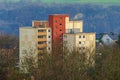 Modern apartment buildings with red central tower stand against a backdrop of trees and hills Royalty Free Stock Photo