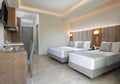 Modern apartment interior of bedroom with oak wood furniture, single, double king size bed, soft grey textile headboard