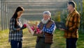 In the modern apple orchard good looking old man farmer and his family together analysing the harvest of this year taste
