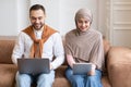 Modern Arab Couple Using Digital Tablet And Laptop At Home Royalty Free Stock Photo