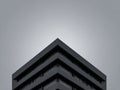 Modern architectural design showcasing a sleek black building against a gray sky during midday Royalty Free Stock Photo