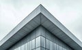 Modern Architectural Design Showcasing Triangular Roof and Large Glass Windows Against Cloudy Sky. Royalty Free Stock Photo