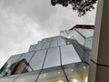 Modern glass facade with a geometric pattern. Glass and steel. Mirrored facade of modern office building with blue sky Royalty Free Stock Photo