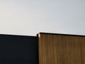 Modern architectural details, wooden wall and black metal wall against sky