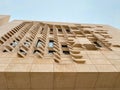 Modern architectural facade with geometric stone pattern and abstract window design