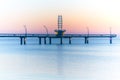Modern architectural pier with lights glowing against pastel sun Royalty Free Stock Photo