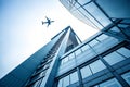 Modern architecture building with flying airplane in background Royalty Free Stock Photo