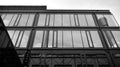 Modern office building wall made of steel and glass with blue sky. Black and white. Royalty Free Stock Photo