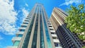 Modern architecture, high-rise residential building, house with glass facade on blue sky background Royalty Free Stock Photo