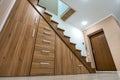 Modern architecture interior with luxury hallway with glossy wooden stairs in multi-storey house. Custom built pullout cabinets on Royalty Free Stock Photo