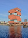 Modern architecture of the MAS museum, refleecting in the water of a dock Antwerp