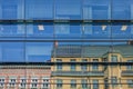 Modern architecture meets with old historical building where old classical buildings reflect in a glazed office facade in downtown Royalty Free Stock Photo