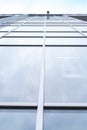 Shooting from lower angle close-up large glass windows of multi-storey office building. Royalty Free Stock Photo